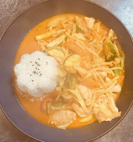 Gaeng Phed Gai: rotes Curry mit Hühnerfleisch, Bambus und Gemüse, Reis in Blütenform